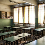 Sala de aula vazia com mesas verdes