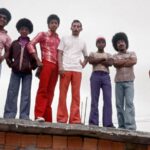 Fotografia de moradores do Aglomerado da Serra, em Belo Horizonte, posando em evento comunitário, parte da exposição 'Retratistas do Morro' no MAR.