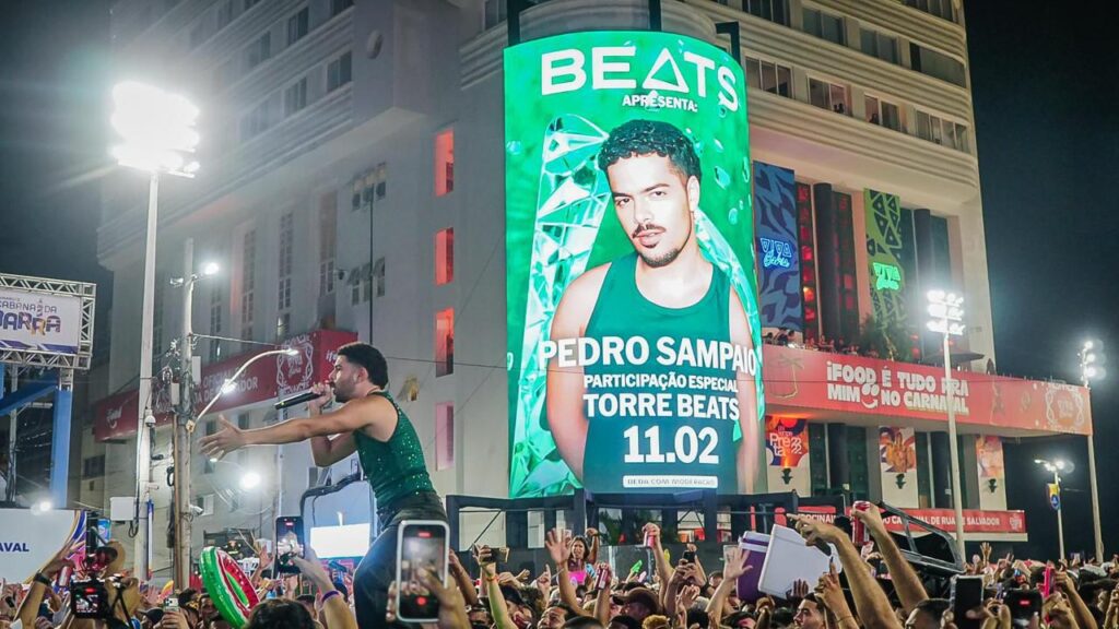 A Beats inaugurou o Carnaval de Salvador 2026 em grande estilo com uma entrada triunfal de Pedro Sampaio, que atravessou a multidão no Farol da Barra montado em um jet ski para abrir a Torre Beats. O evento marcou o início de uma edição histórica focada na valorização da cena local, apresentando um line-up composto 100% por artistas baianos, como O Kannalha e Diggo, unindo ritmos como o pagodão e o afrobeat. Além do espetáculo musical, a marca aproveitou a visibilidade do circuito Barra-Ondina para lançar o Beats Green Mix, consolidando-se como um hub de inovação e cultura jovem ao misturar marketing de experiência com o DNA cultural da Bahia.